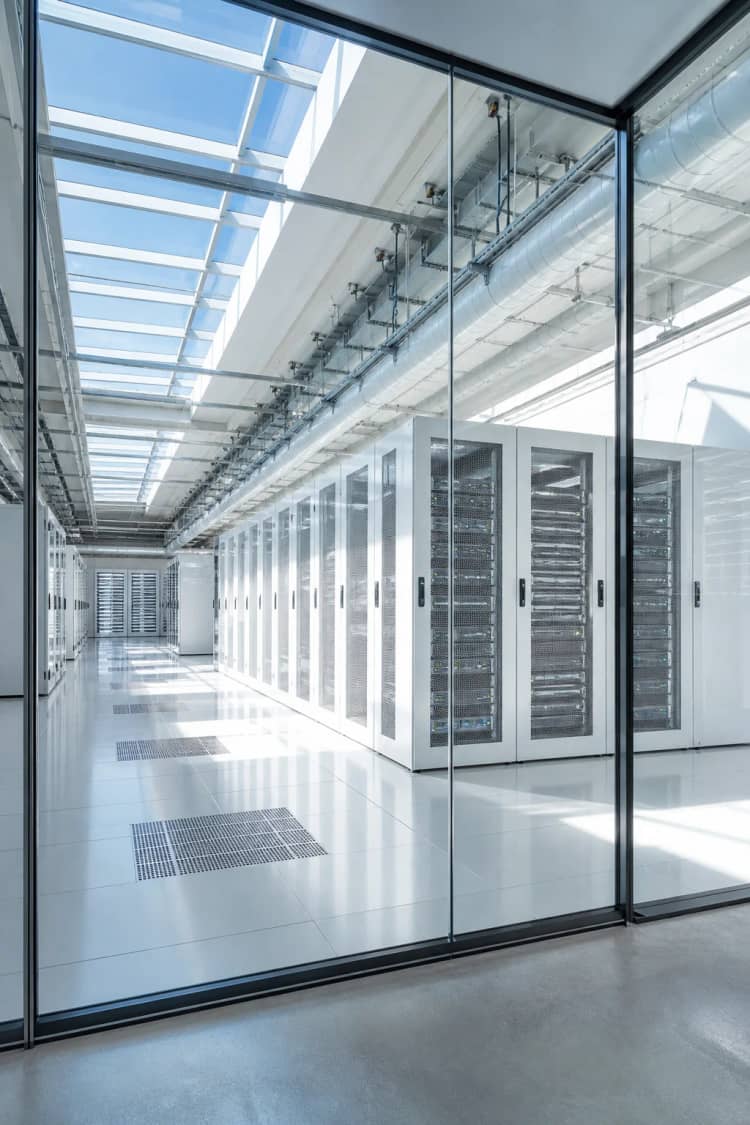 Daylit data hall with pale server racks and skylights